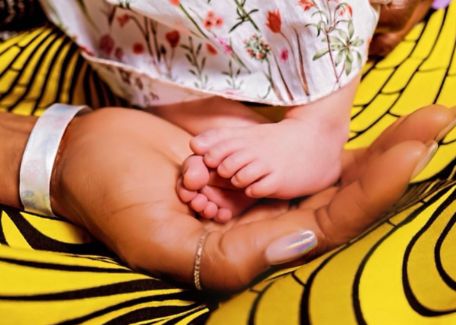 Naomi Campbell hugs her daughter's feet