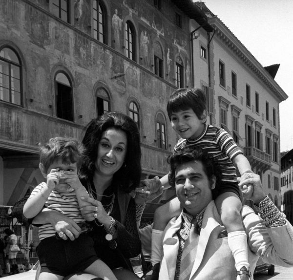 Mexican soprano Marta Ornelas holds her son Alvaro Domingo in front of the Palazzo dell'Antella in Piazza Santa Croce ) with a toy camera in hand.Next to her, her Spanish husband and tenor Placido Domingo smiles with their son and Mexican singer Placido Domingo Jr., Florence, 1970s