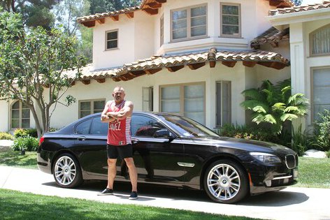 Chuck Liddell standing outside his house and car