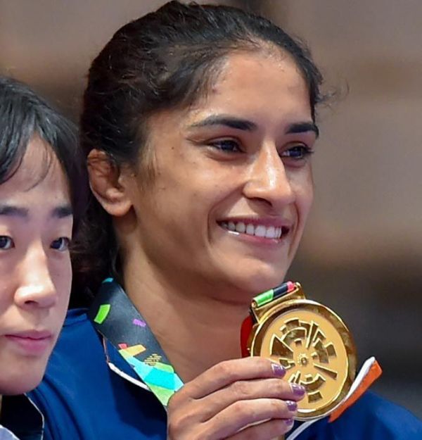 Vinesh Phogat shows off her gold medal on the podium after the 50kg wrestling event at the 2018 Asian Games