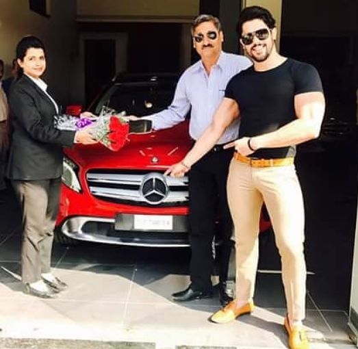 Shivashish Mishra standing next to his Mercedes
