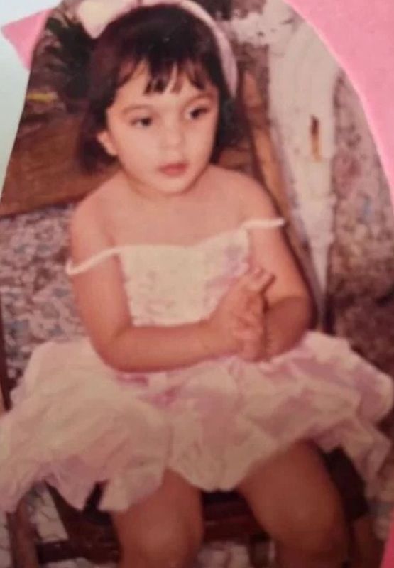 Kiara wears an off-the-shoulder dress in her childhood photo