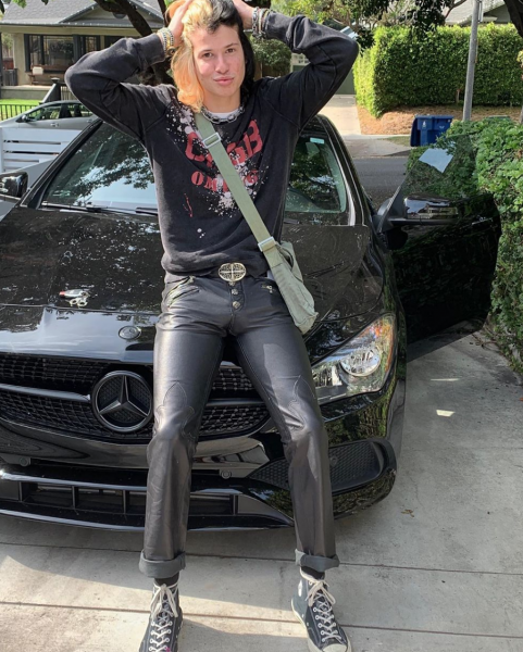 Slash poses for a photo with her car